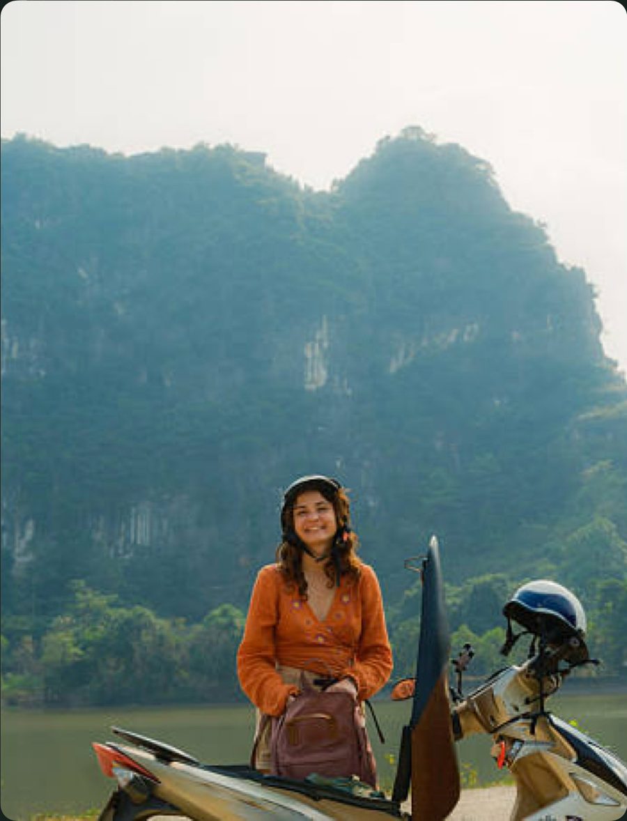 A local host with her motorcycle on a mountain pass